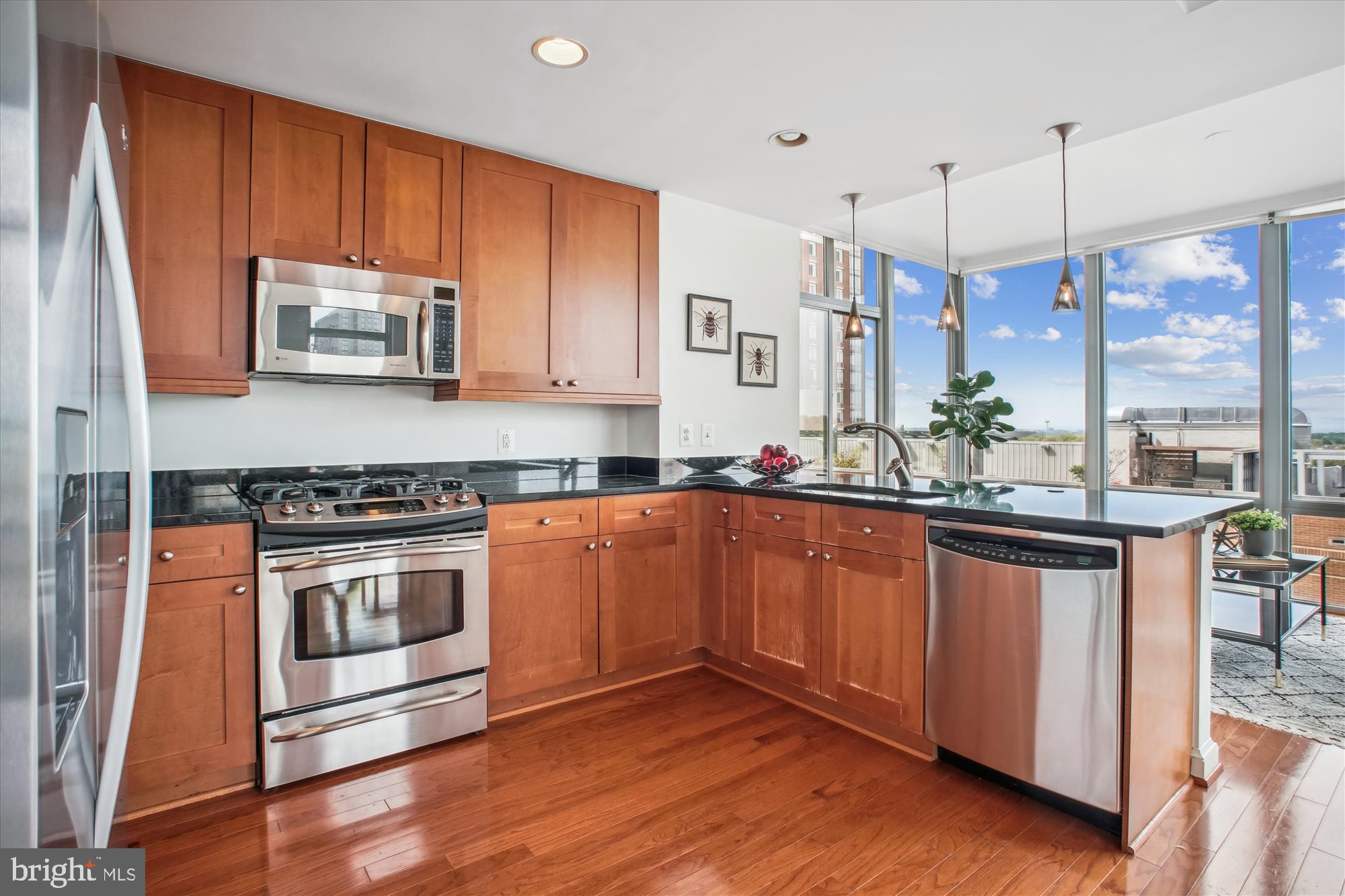 11990 Market Street, Unit 805 Reston, VA 20190 - Photo 12 of 53 a kitchen with stainless steel appliances granite countertop a stove a sink and a microwave