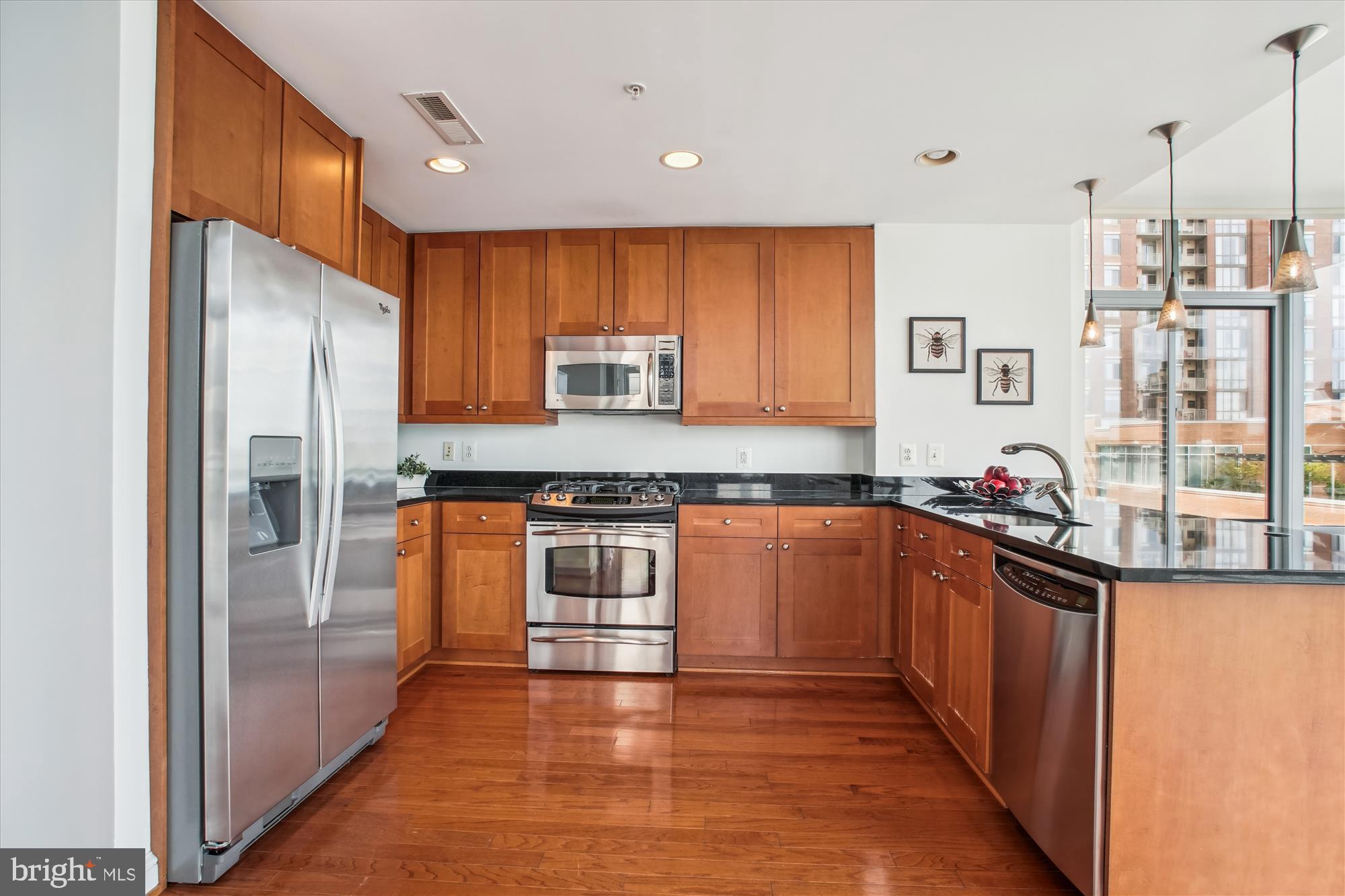 11990 Market Street, Unit 805 Reston, VA 20190 - Photo 13 of 53 a kitchen with stainless steel appliances granite countertop a refrigerator and a stove top oven