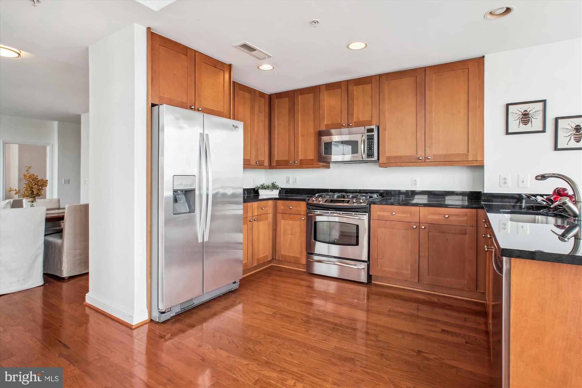 11990 Market Street, Unit 805 Reston, VA 20190 - Photo 14 of 53 a kitchen with granite countertop a refrigerator and a stove top oven