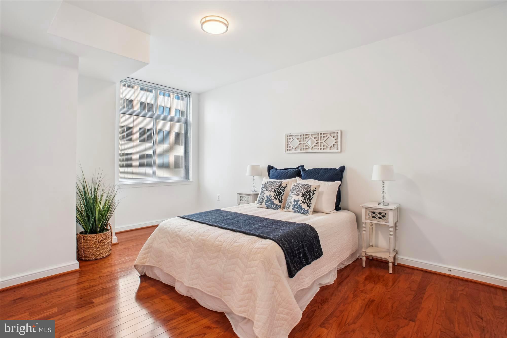 11990 Market Street, Unit 805 Reston, VA 20190 - Photo 25 of 53 a bedroom with a bed and wooden floor