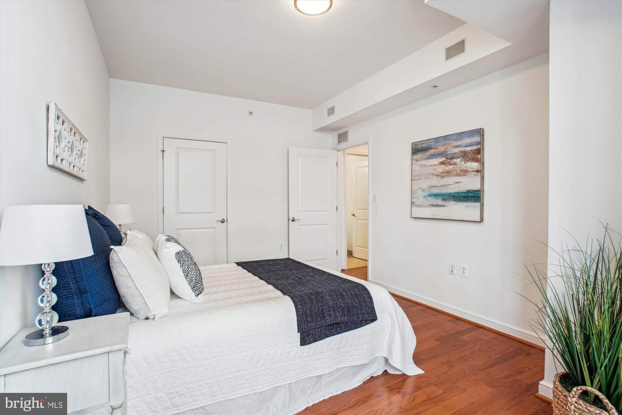 11990 Market Street, Unit 805 Reston, VA 20190 - Photo 26 of 53 a bedroom with a bed and a potted plant