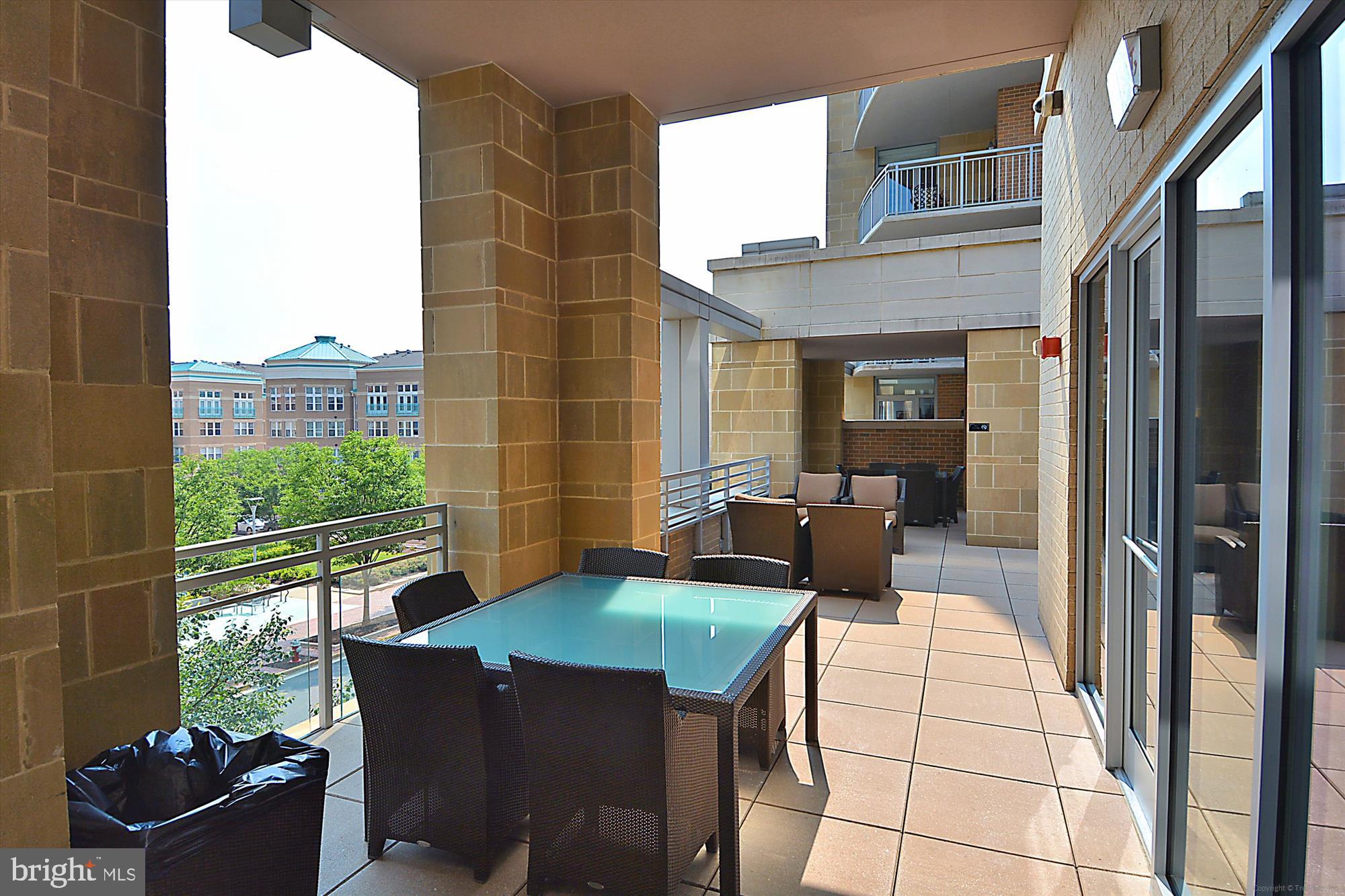 11990 Market Street, Unit 805 Reston, VA 20190 - Photo 41 of 53 a view of a patio with a dining table and chairs