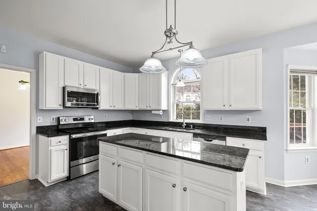 a kitchen with granite countertop a refrigerator oven a sink and dishwasher