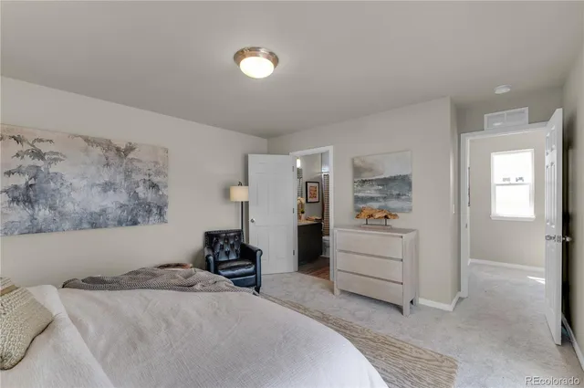 a bed room with a bed and a view of kitchen