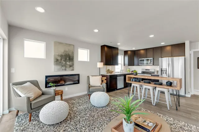 a living room with furniture a kitchen counter and chairs