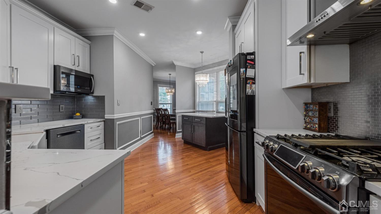 68 Timber Ridge Road North Brunswick, NJ 08902 - Photo 6 of 37 a kitchen with stainless steel appliances granite countertop a stove top oven a sink dishwasher and a refrigerator with wooden floor