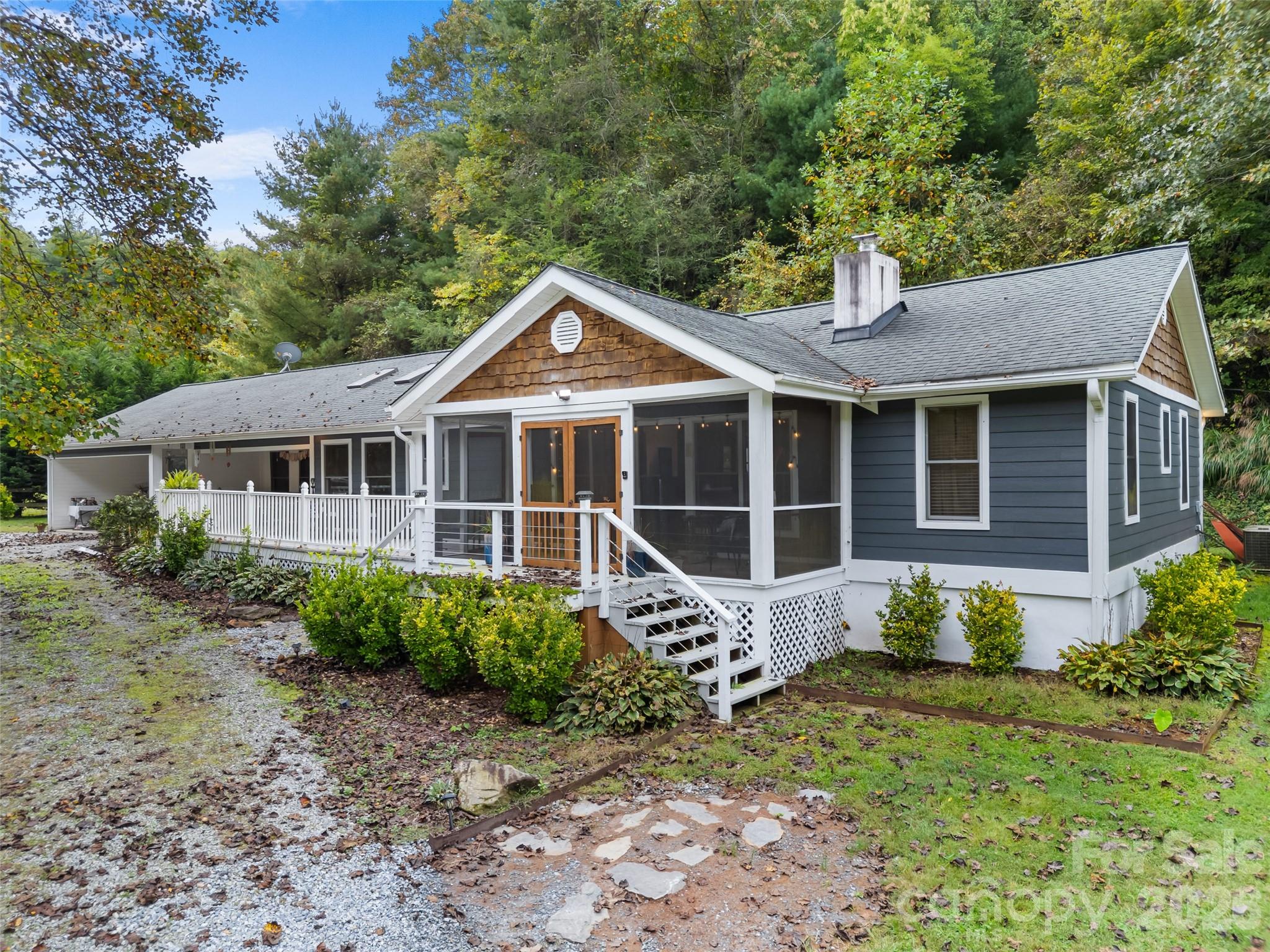 645 West Fork Creek Road Saluda, NC 28773 - Photo 1 of 44 a front view of a house with a garden and porch