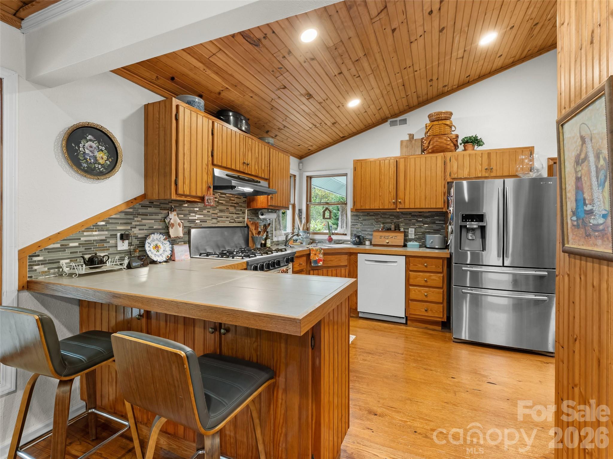 645 West Fork Creek Road Saluda, NC 28773 - Photo 10 of 44 a kitchen with kitchen island a stove a refrigerator and a refrigerator with wooden floor