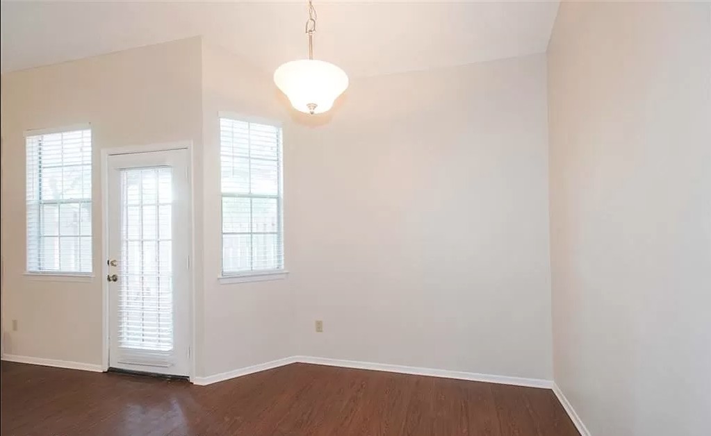6501 Brush Country Road, Unit 102 Austin, TX 78749 - Photo 7 of 12 Rich hardwood floors complement neutral walls in this light-filled room featuring a glass-paned door.