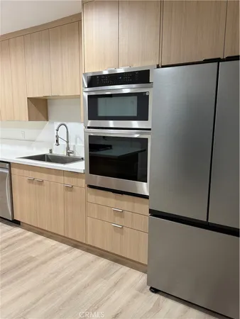 a kitchen with cabinets and white stainless steel appliances