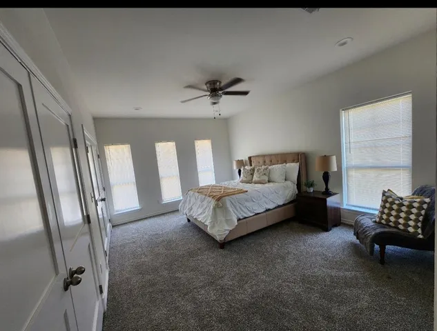 a spacious bedroom with a bed and a window