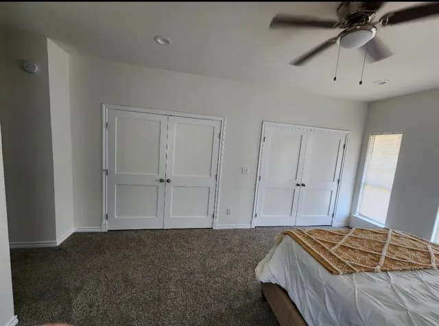 a bedroom with a bed and a ceiling fan