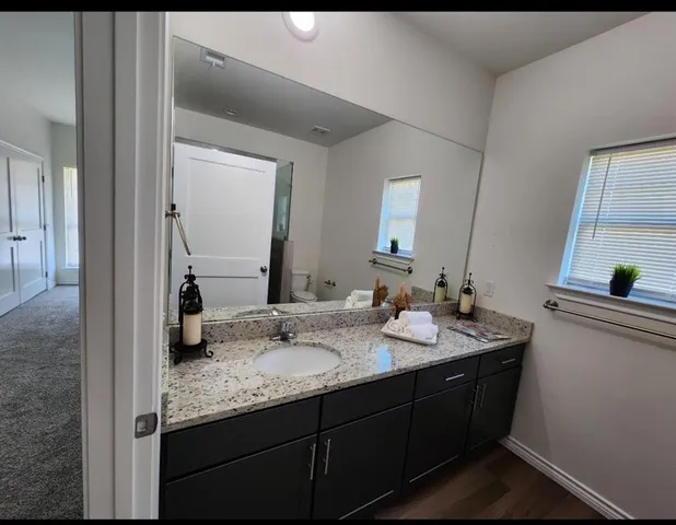 a bathroom with a granite countertop sink and a mirror