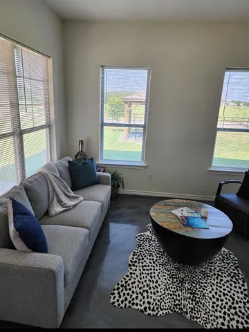 a living room with furniture a window and a table