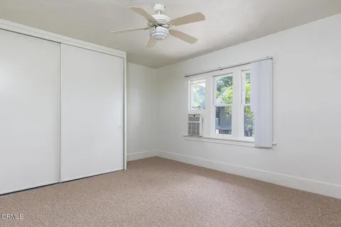 an empty room with a window and a fan