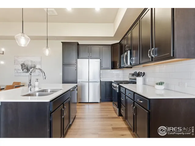 a kitchen with kitchen island a sink stainless steel appliances and cabinets