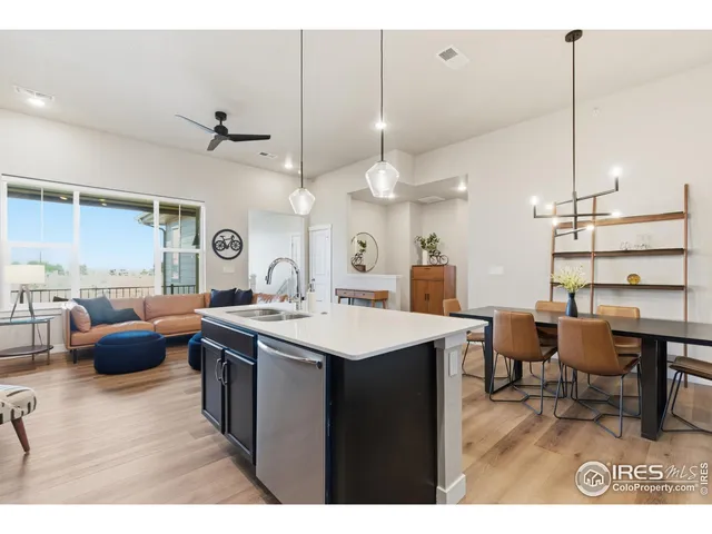 a kitchen with a stove a refrigerator a dining table and chairs with wooden floor