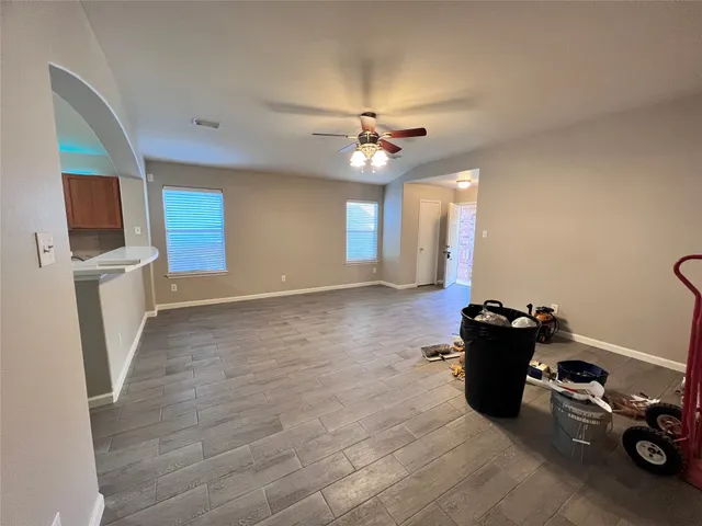a view of a room with wooden floor and a ceiling fan