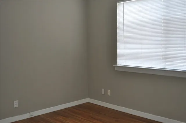 a view of a small space with wooden floor and a window