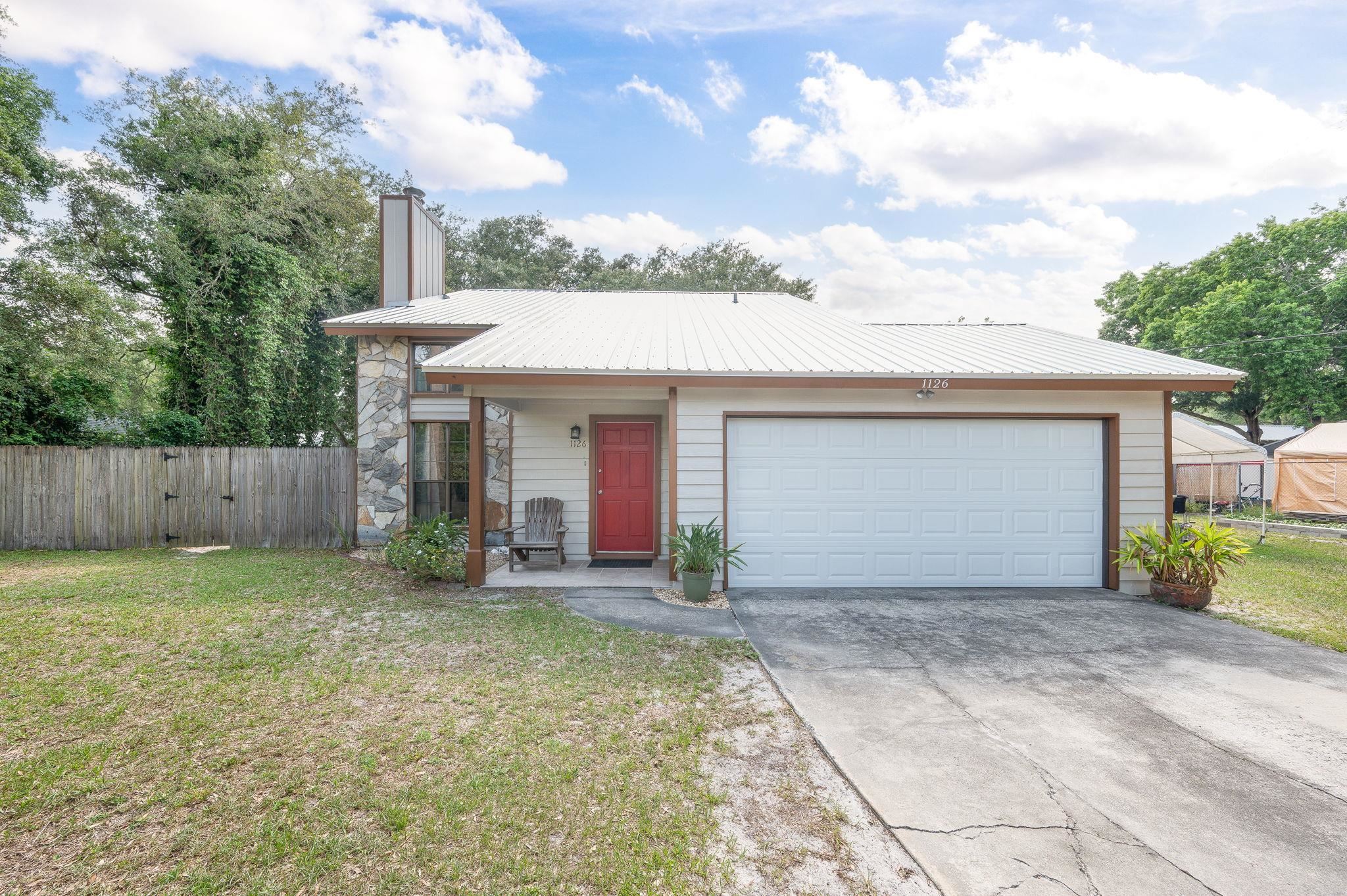 1126 Prince Road St. Augustine, FL 32086 - Photo 2 of 42 a front view of a house with a yard and garage