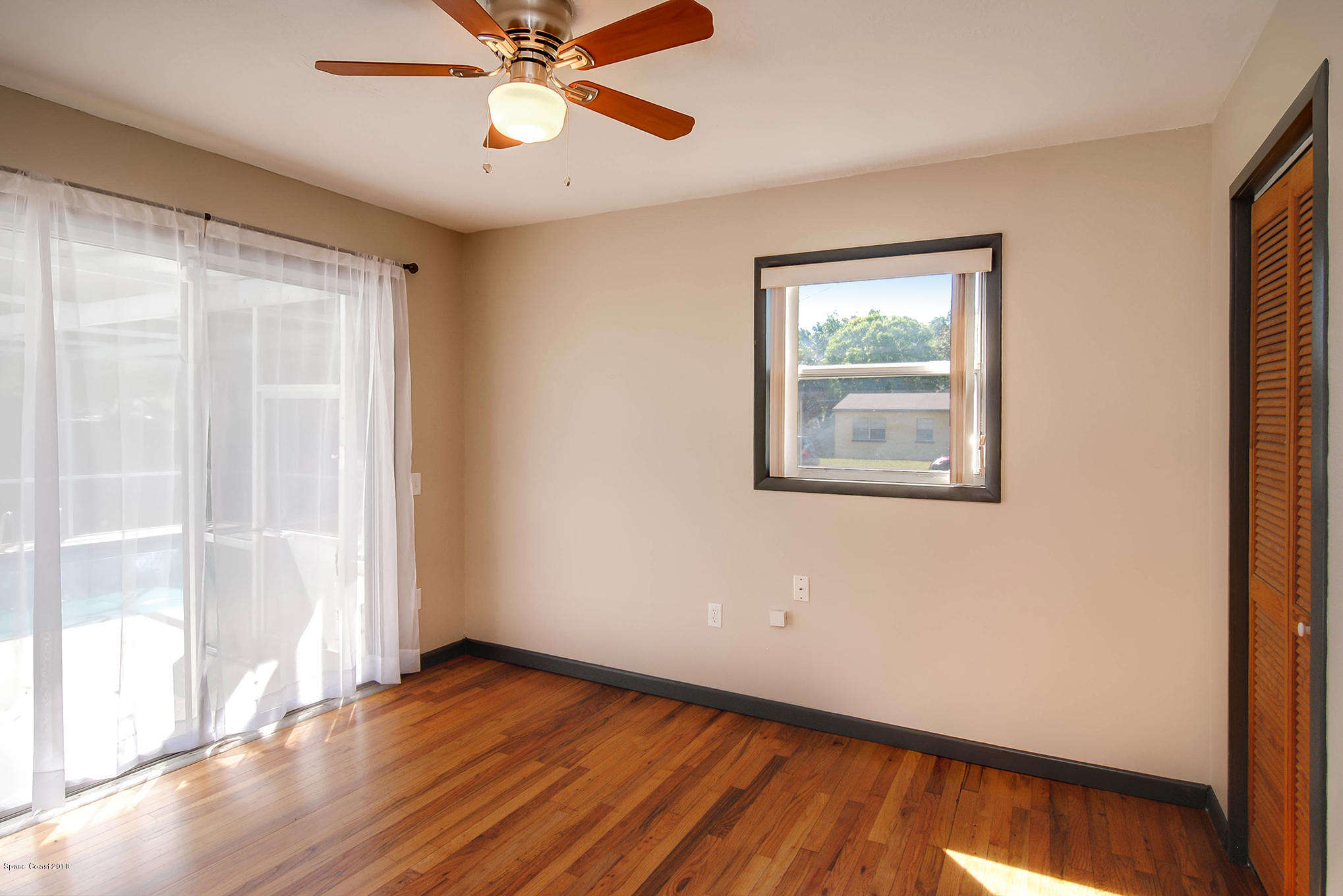 1053 Bernice Road Rockledge, FL 32955 - Photo 23 of 30 a view of an empty room with wooden floor and a window
