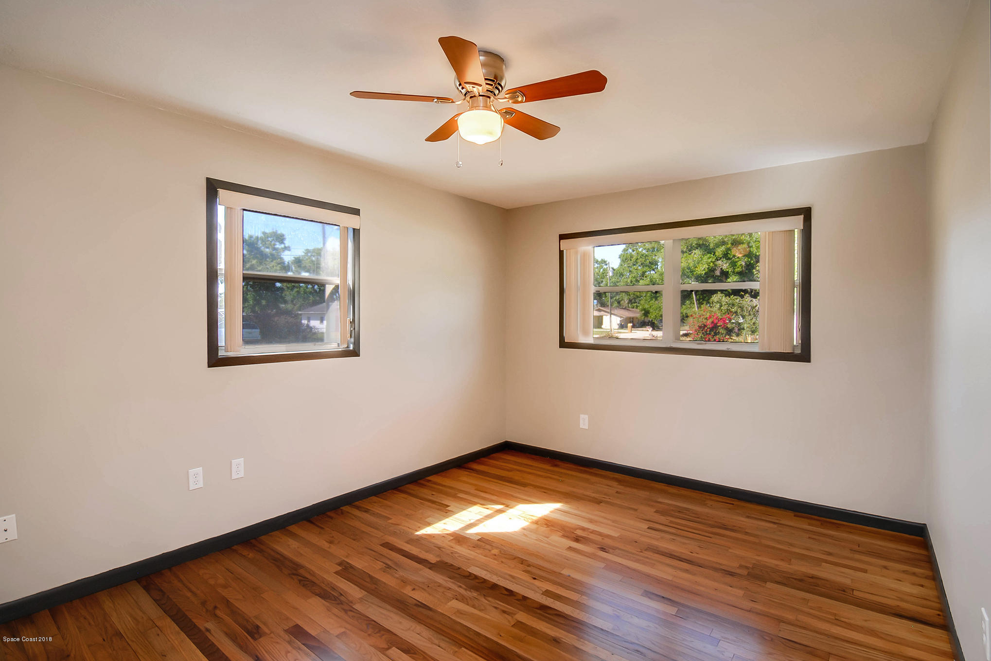 1053 Bernice Road Rockledge, FL 32955 - Photo 25 of 30 a view of an empty room with wooden floor and a ceiling fan