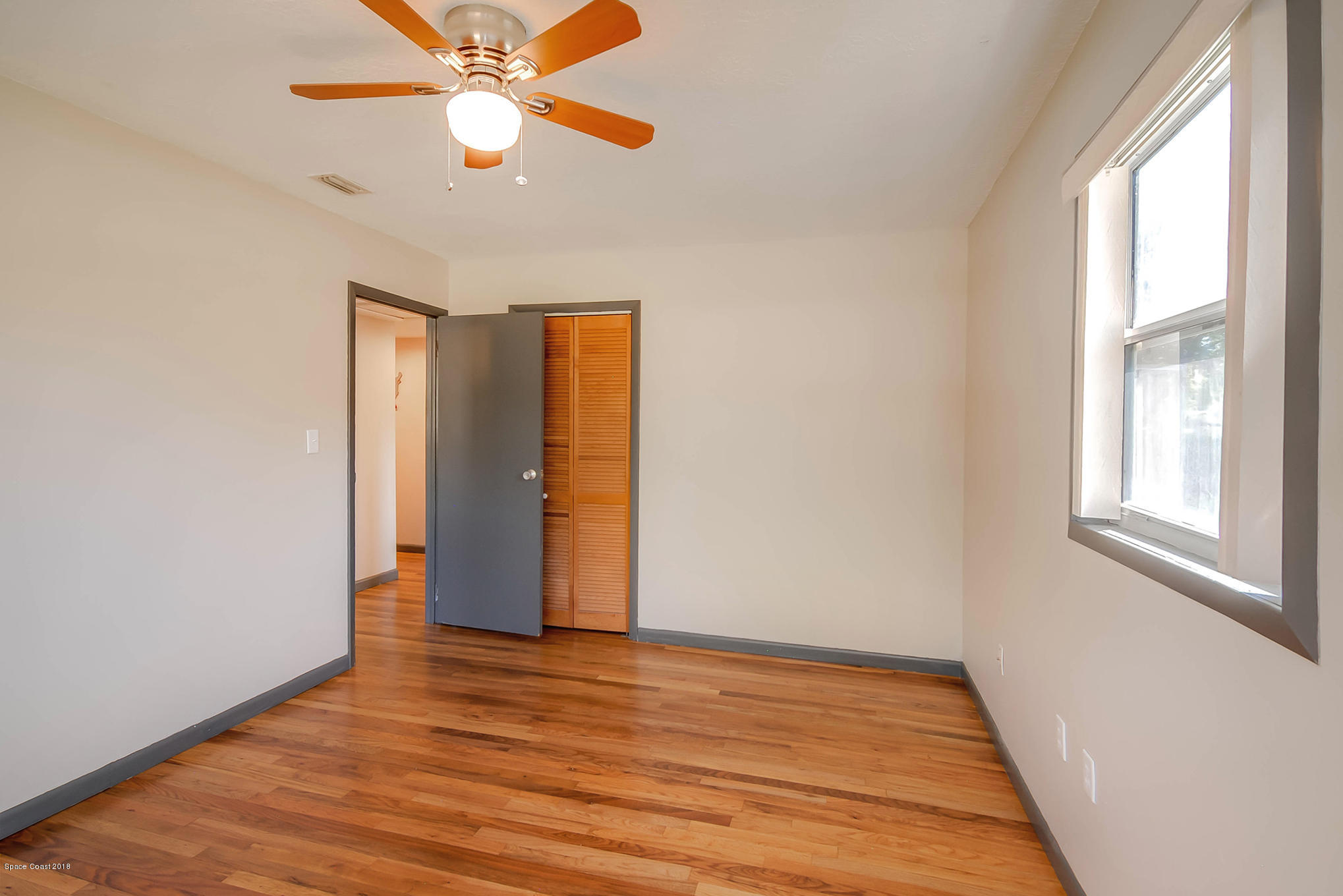 1053 Bernice Road Rockledge, FL 32955 - Photo 26 of 30 a view of an empty room with wooden floor and a window