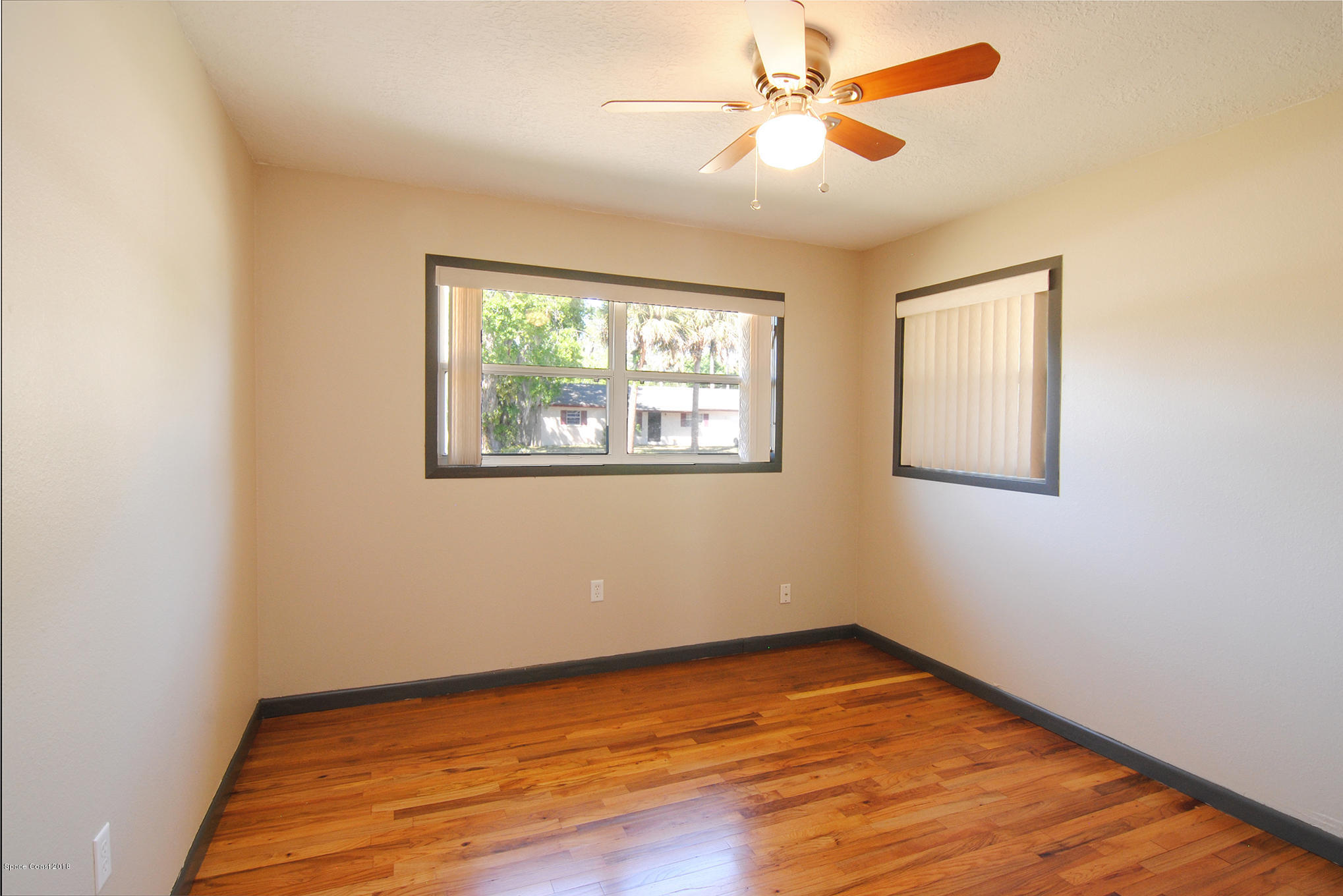 1053 Bernice Road Rockledge, FL 32955 - Photo 27 of 30 a view of empty room with wooden floor and fan