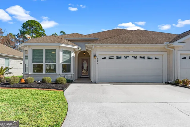 a front view of a house with a yard and outdoor seating