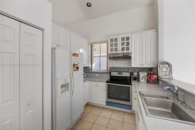 a kitchen with granite countertop a refrigerator and a sink