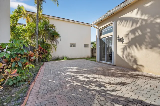 a view of a house with a small yard and wooden fence