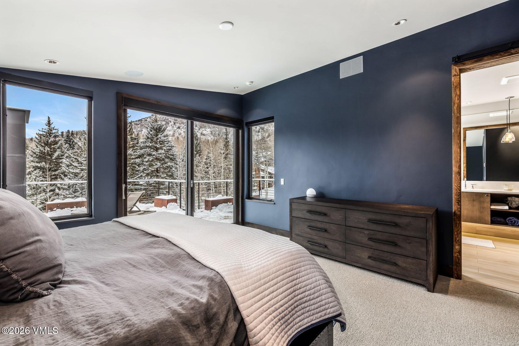2440 Chamonix Lane Vail, CO 81657 - Photo 17 of 36 a bedroom with a bed and large windows