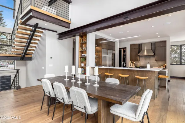 a dining area with a table chairs and a kitchen view