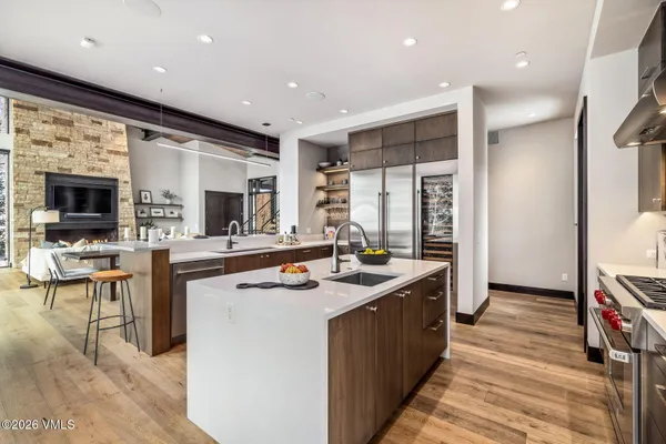 a kitchen with stainless steel appliances granite countertop a sink and a refrigerator