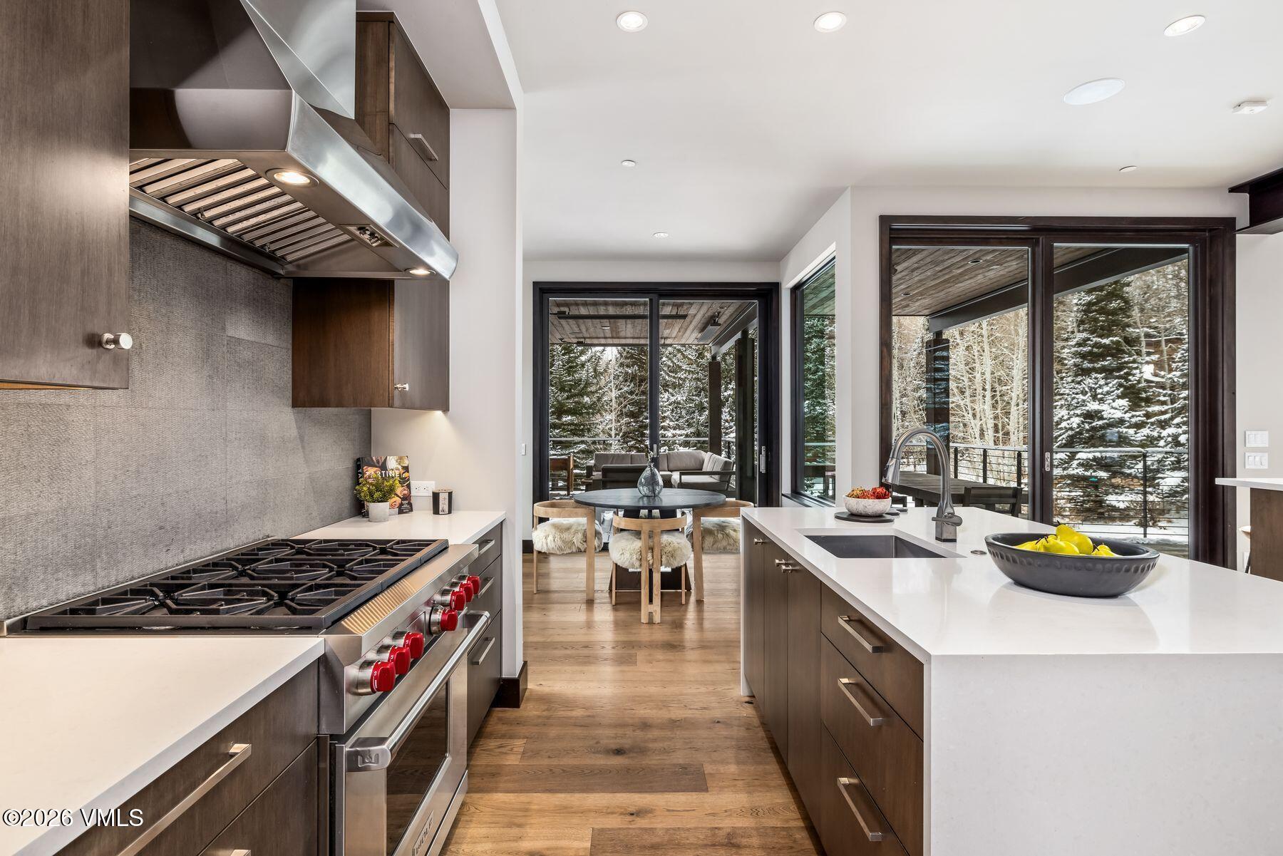 2440 Chamonix Lane Vail, CO 81657 - Photo 9 of 36 a kitchen with a stove a sink a dining table and chairs