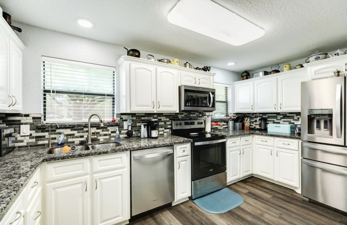 131 Bastrop Bayou Drive Angleton, TX 77515 - Photo 12 of 36 a kitchen with white cabinets and appliances