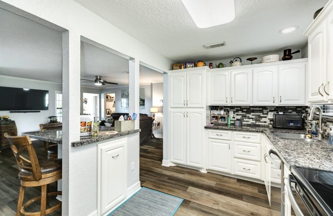 131 Bastrop Bayou Drive Angleton, TX 77515 - Photo 13 of 36 a kitchen with white cabinets and appliances