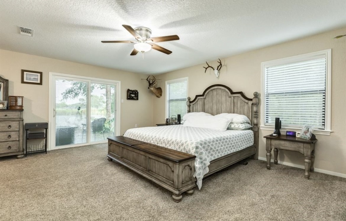 131 Bastrop Bayou Drive Angleton, TX 77515 - Photo 17 of 36 a bedroom with a bed and a chandelier