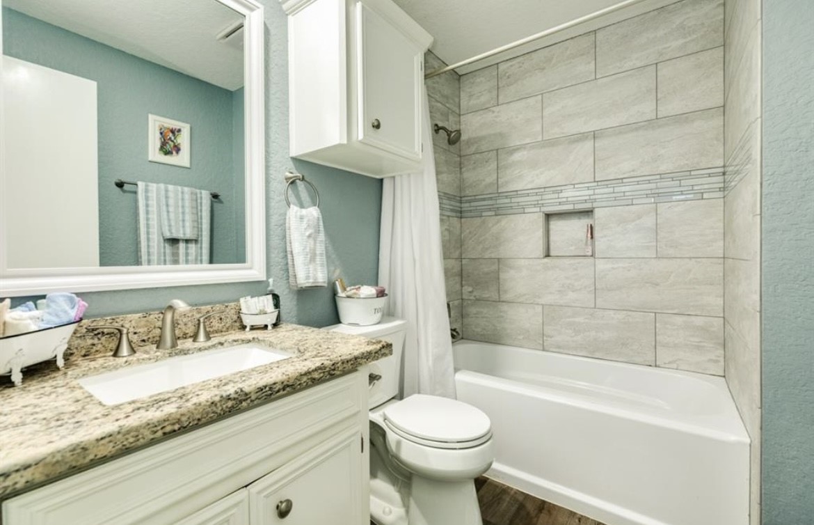 131 Bastrop Bayou Drive Angleton, TX 77515 - Photo 22 of 36 a bathroom with a granite countertop bathtub shower sink vanity mirror and toilet