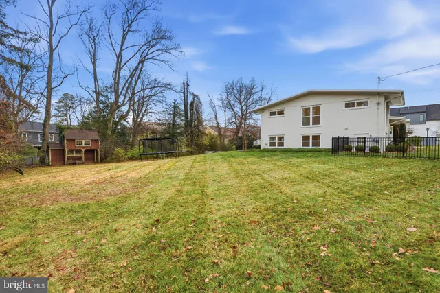 a view of a large house with a big yard and large trees