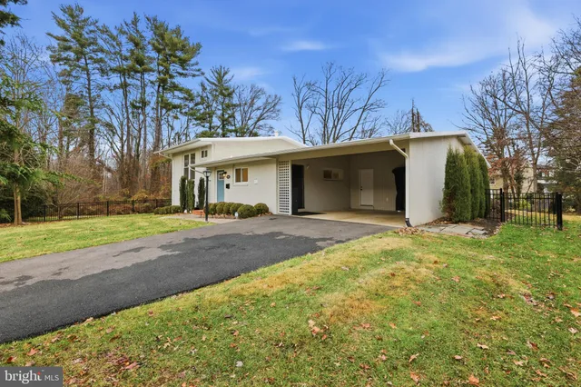 a view of a white house with a big yard and large tree