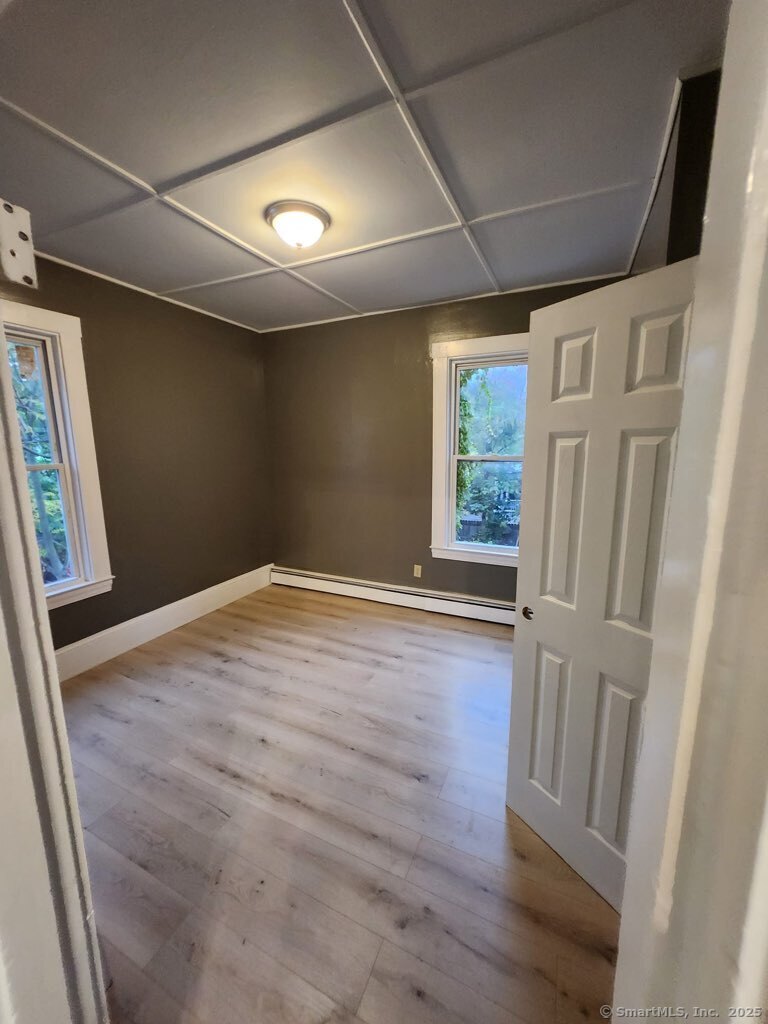 199 Jefferson Street Hartford, CT 06106 - Photo 4 of 9 an empty room with wooden floor and window