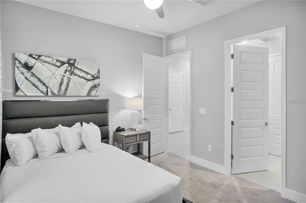 7740 Sandy Ridge Drive, Unit 106 Reunion, FL 34747 - Photo 18 of 43 a bedroom with a bed and a lamp