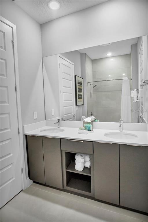 7740 Sandy Ridge Drive, Unit 106 Reunion, FL 34747 - Photo 21 of 43 a bathroom with a sink and a mirror