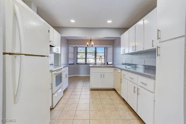 a kitchen with white cabinets and white appliances