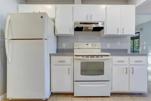 a kitchen with stainless steel appliances white cabinets and a refrigerator