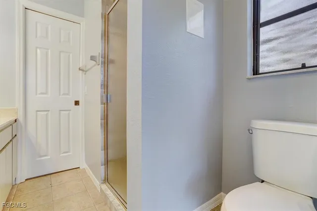 a white toilet sitting next to a shower