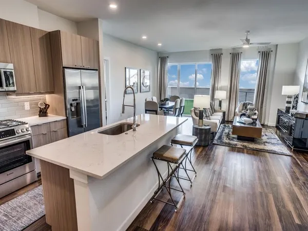 a large kitchen with a table chairs refrigerator and cabinets