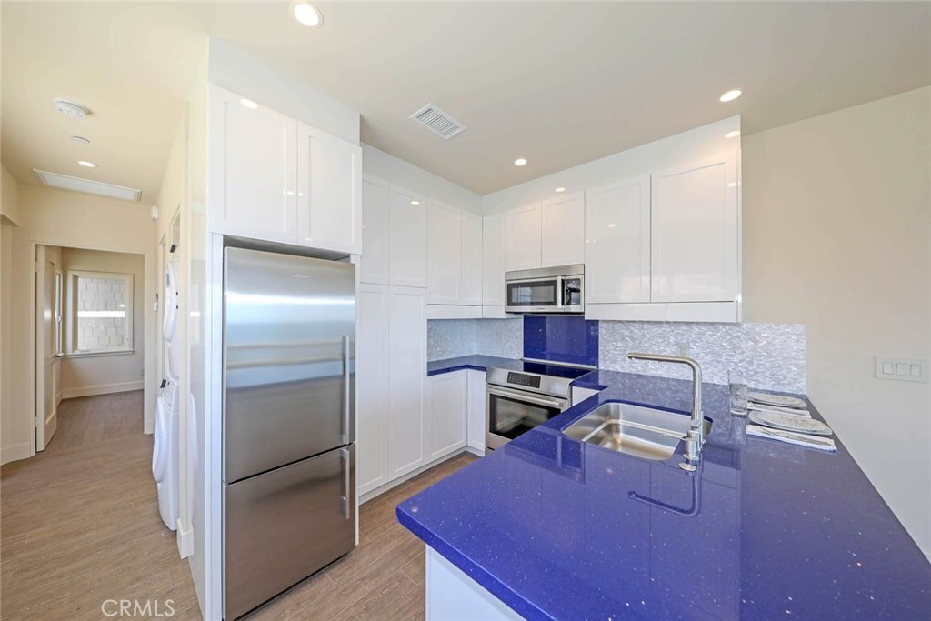 376 Cliff Drive, Unit C Laguna Beach, CA 92651 - Photo 11 of 22 a kitchen with a refrigerator and a wooden cabinets