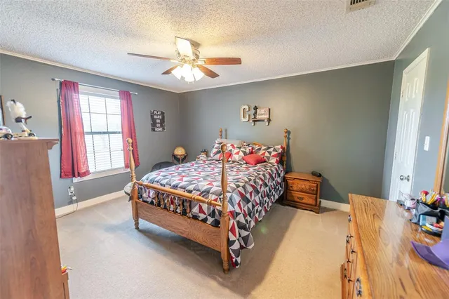 a bedroom with a bed chandelier and a window